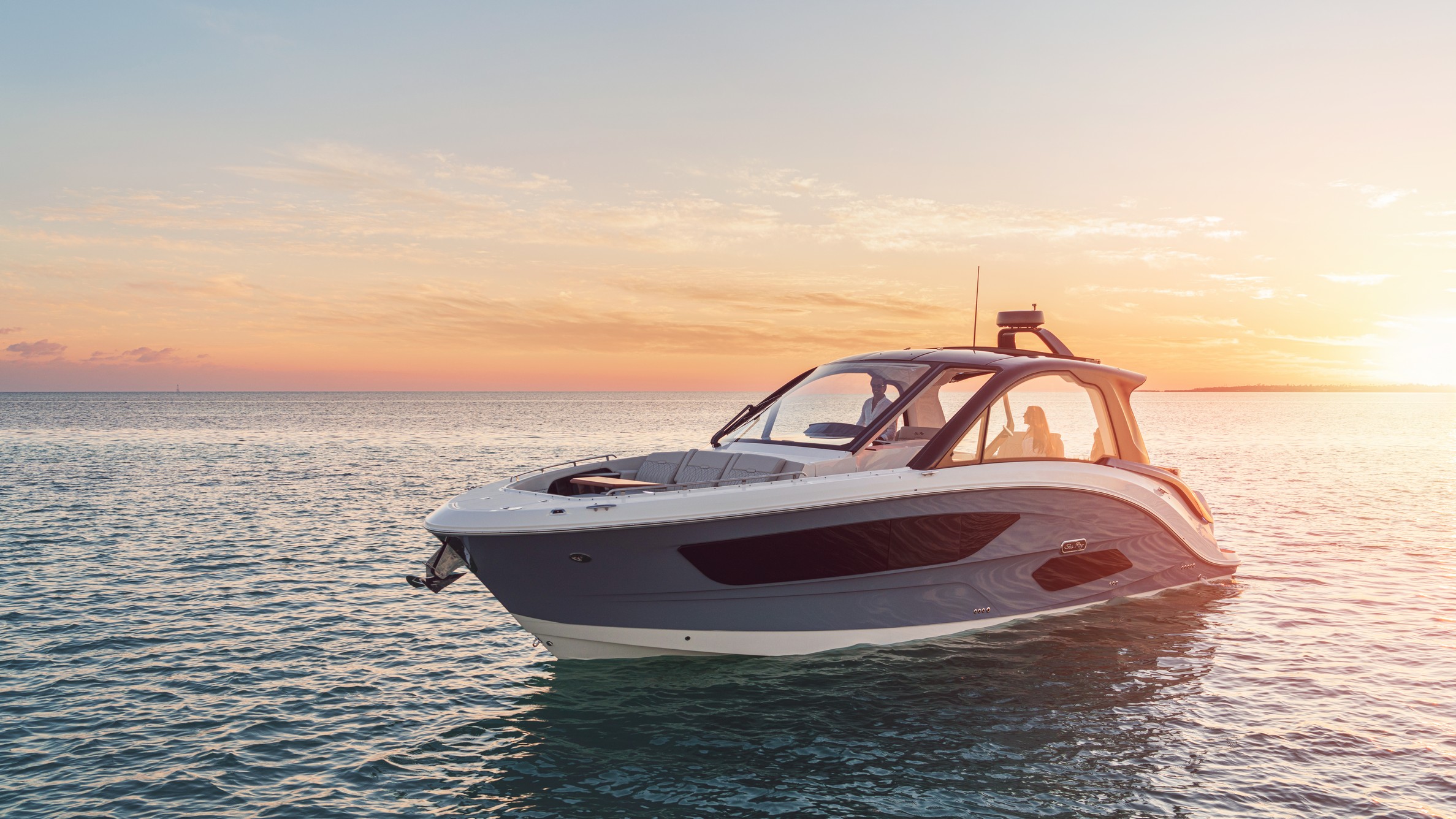 2021 Sundancer 370 Outboard Dao370 Lifestyle Port Bow Three Quarter Couple Sunset 06117 Select